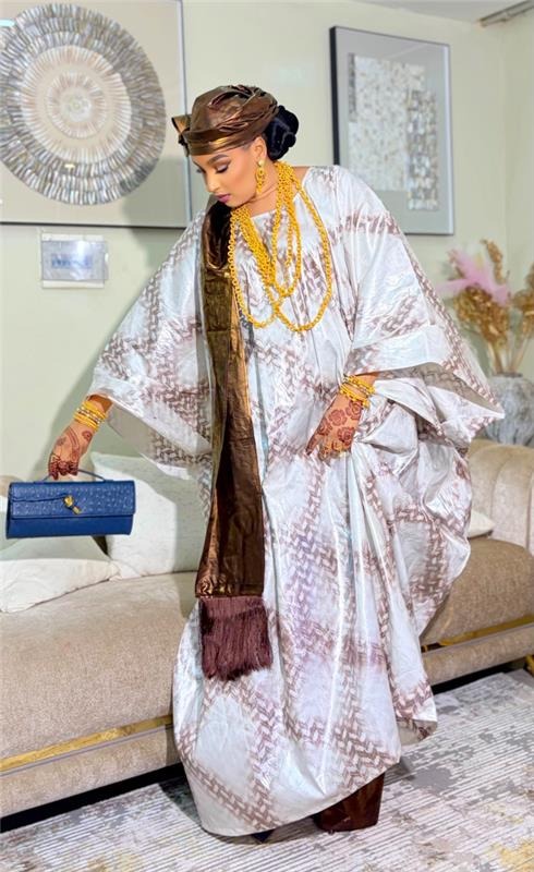 Femme en boubou brodé avec pochette bleue, studio Doucshoot